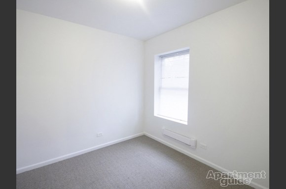 a small room with white walls and a window